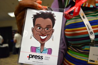 Debra Bass holds up a caricature drawn by Radix' Julia Kelly at the Online News Association Career Fair on Friday, September 25, 2015. (Photo by Nathalie Dortonne/ONA Student Newsroom)