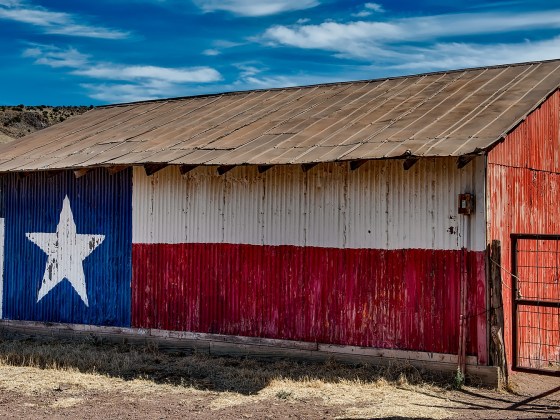 Metal side of a barn, decorated with a painting of the Flag of Texas, near Fort Davis in Jeff Davis County, Texas.