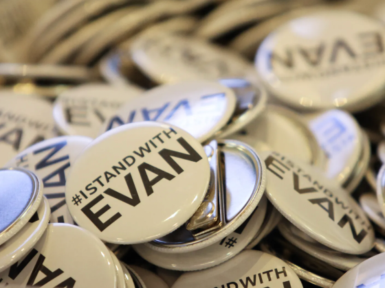 A pile of white pins reading #IStandWithEvan
