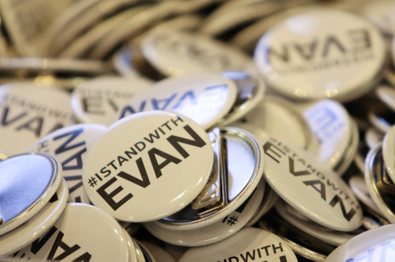 A pile of white pins reading #IStandWithEvan